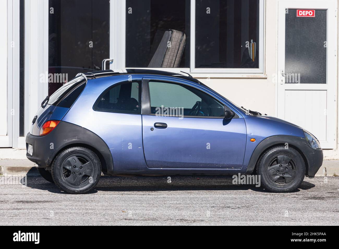 Side, Turkey -January 22, 2022:   blue Ford Ka  is parked  on the street on a warm day against the backdrop of a fence, garden Stock Photo