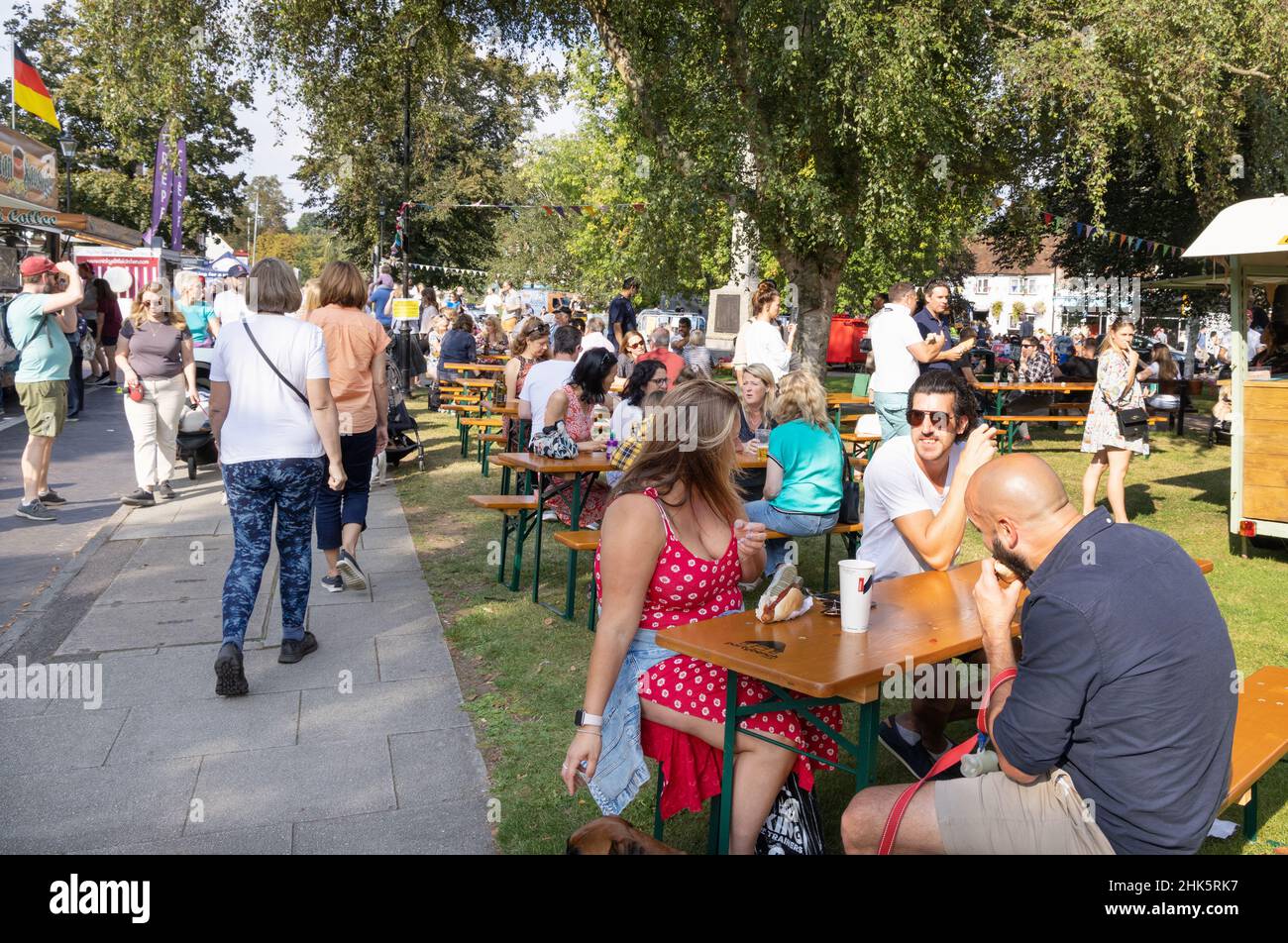 Summer UK; A crowd of people sitting outdoors in the sunshine on the