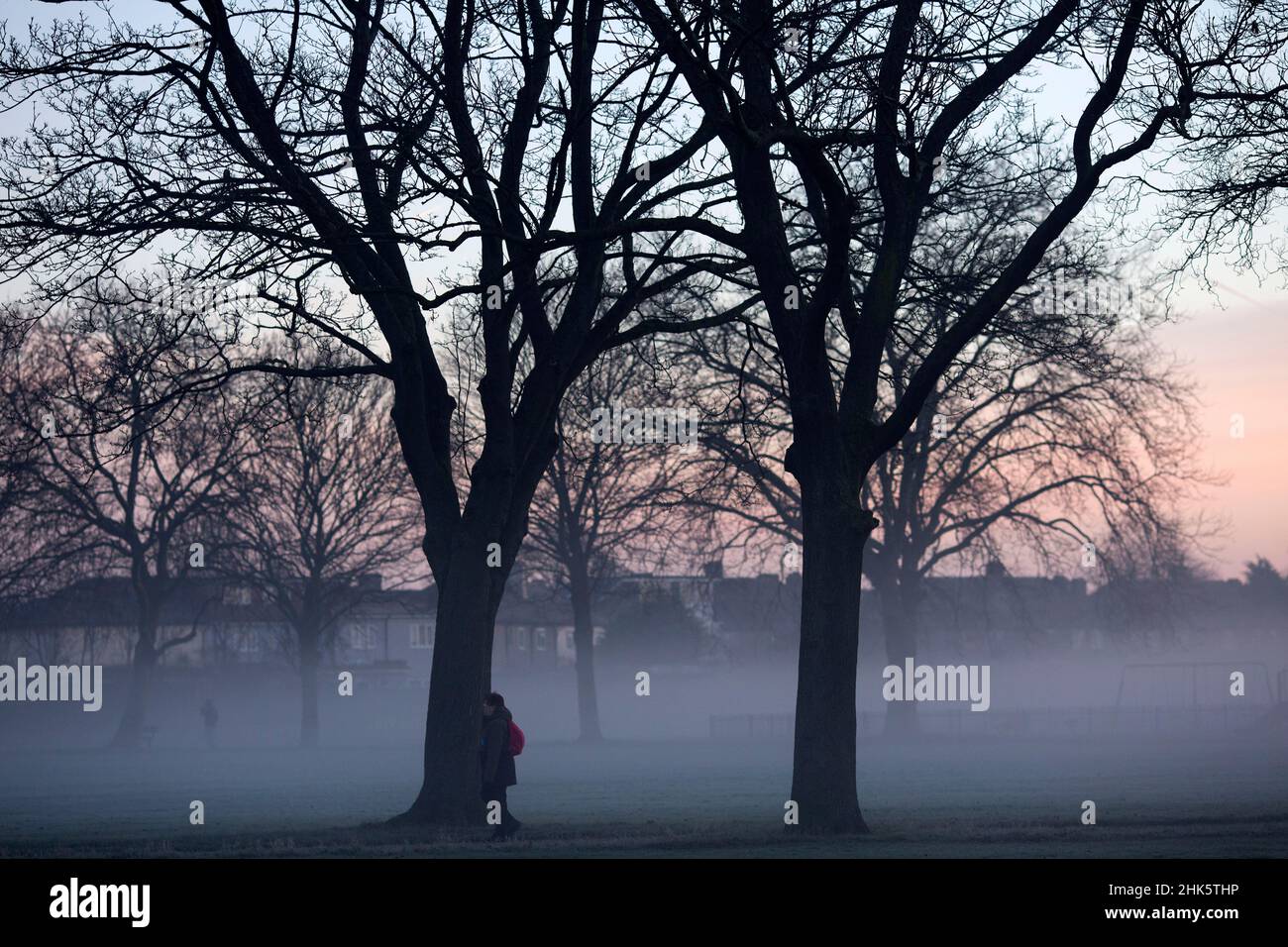 Pedestrians walk in a mistcovered park in Ilford, East London, in the