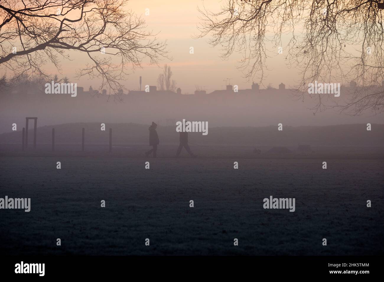 Pedestrians walk in a mistcovered park in Ilford, East London, in the