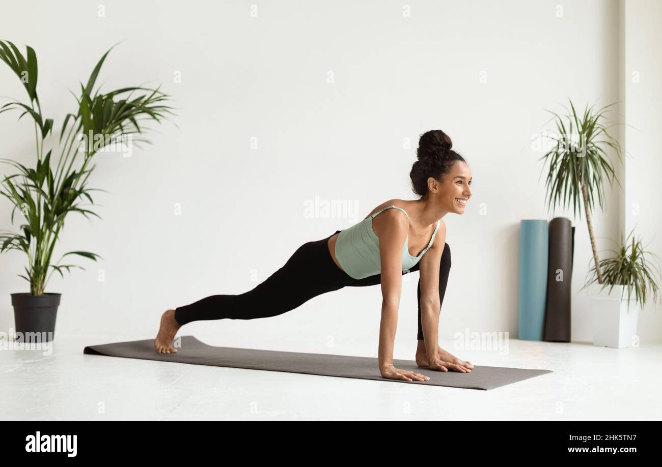 Young beautiful female making yoga training in modern spacious studio Stock Photo