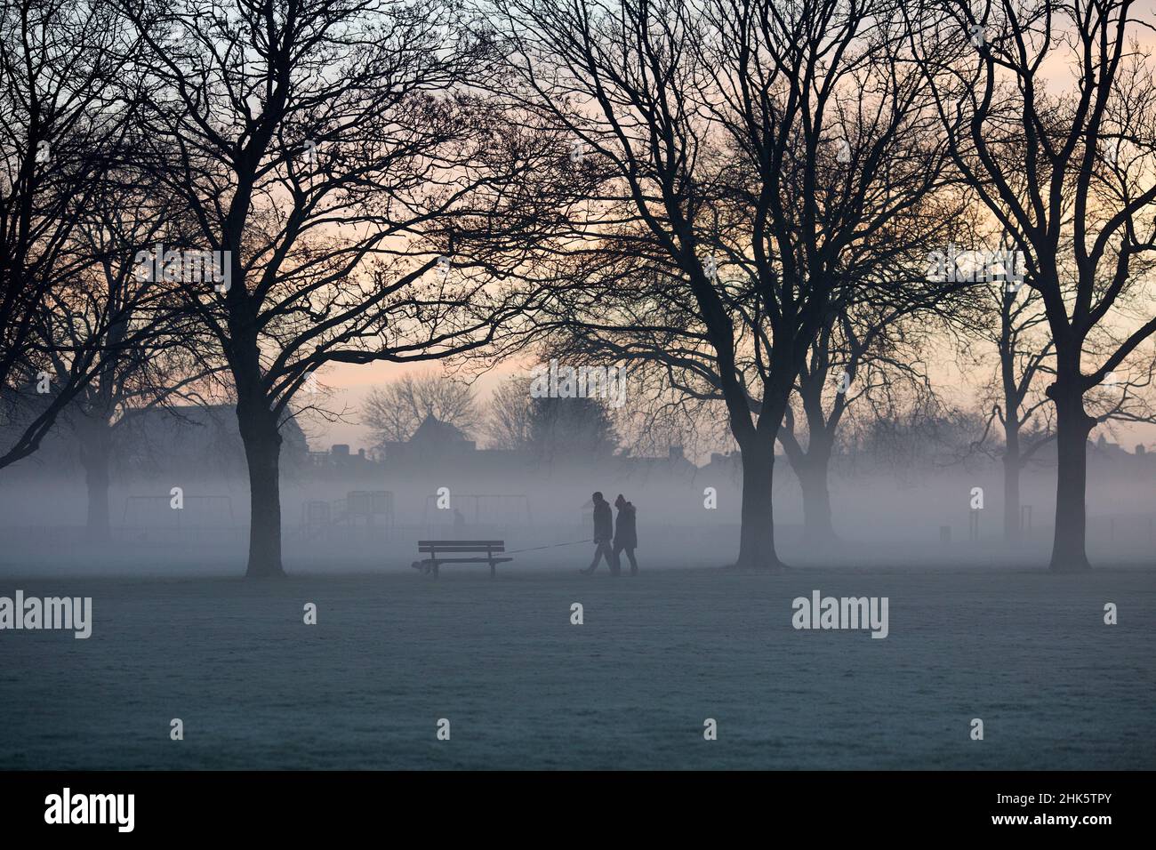 Pedestrians walk in a mistcovered park in Ilford, East London, in the