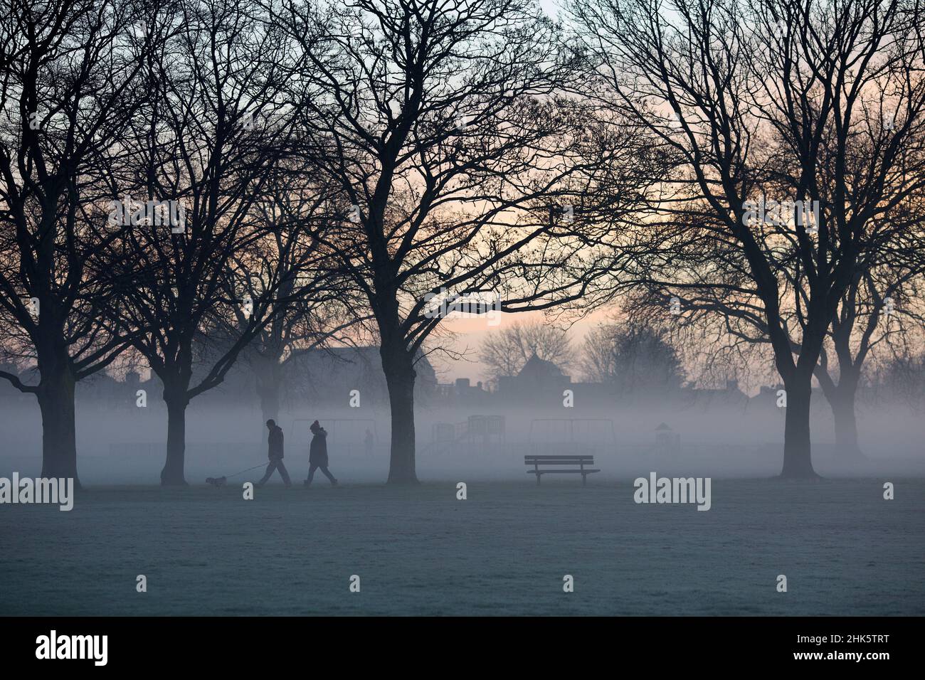 Pedestrians walk in a mistcovered park in Ilford, East London, in the