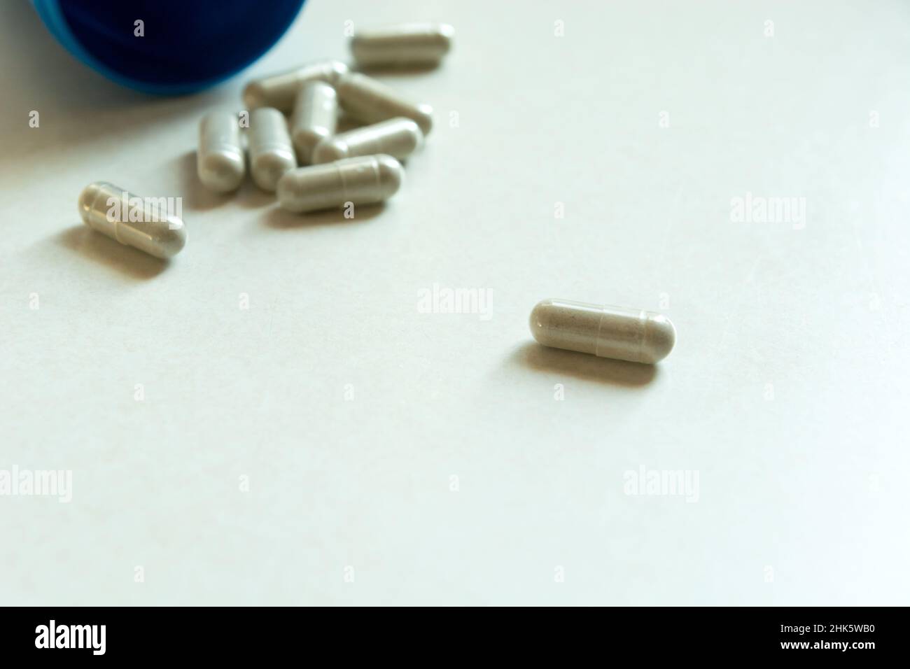 Close up of pills in capsules on a white countertop Stock Photo