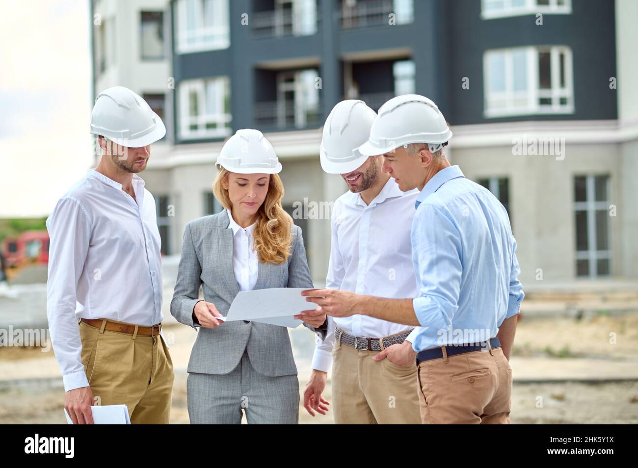 Concentrated professional female inspector checking project documentation Stock Photo