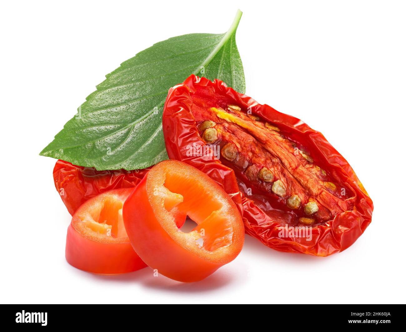 Dried or Sundried tomato halves with chile pepper and basil isolated Stock Photo