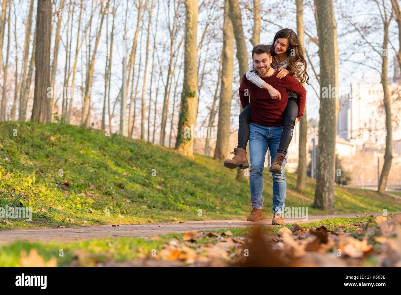 Young heterosexual couple walking and playing in a park on valentine's ...