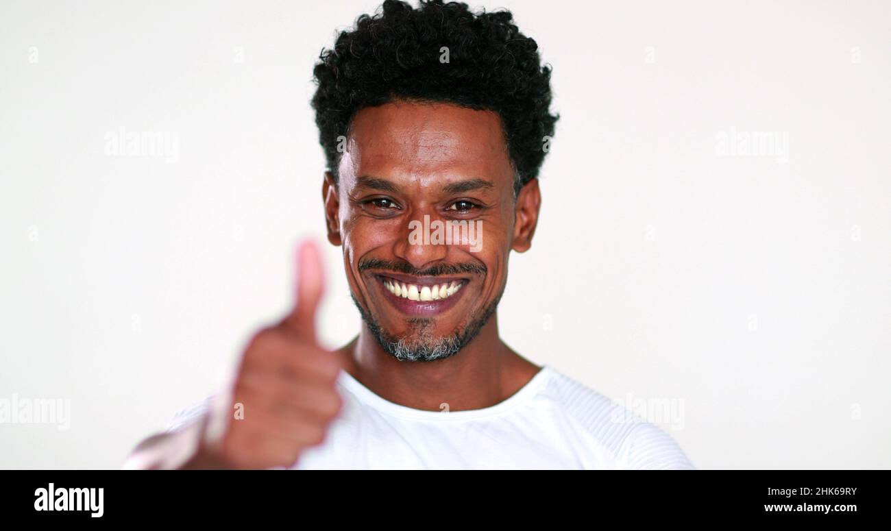 Smiling African black guy portrait being positive giving thumb up with approval Stock Photo