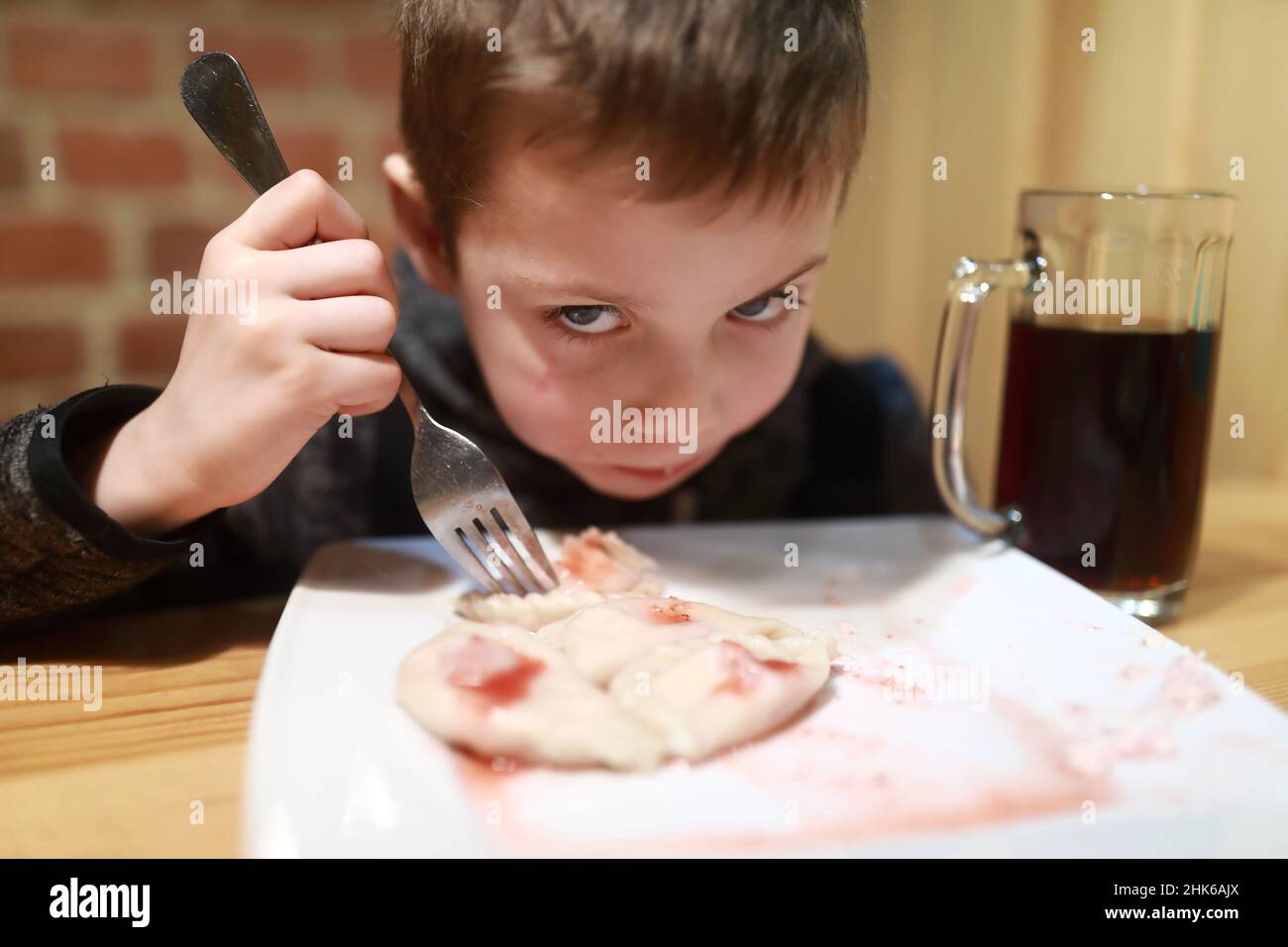 Child eating vareniki with raspberry jam in restaurant Stock Photo - Alamy