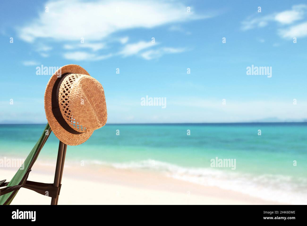 Vacation background with straw hat and bright tropical beach in summer. Holidays backdrop with copy space Stock Photo
