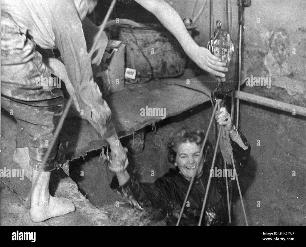 Smiling escapee is hauled into West Berlin from a tunnel under the Berlin Wall, West Berlin, Germany, 1964. Stock Photo
