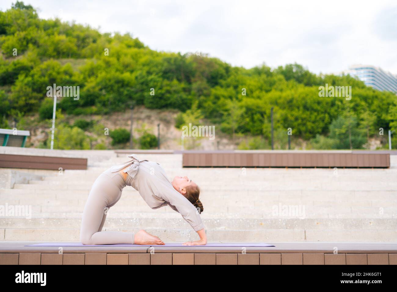 Side view of young gymnast woman performs enjoying bending body