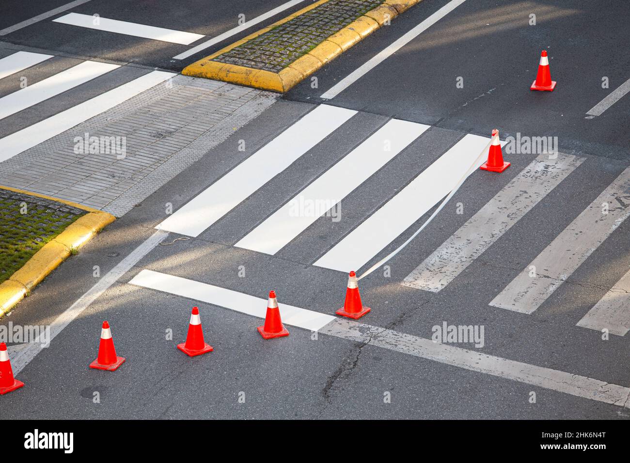 Zebra crossing in the process of being painted with masking tape and