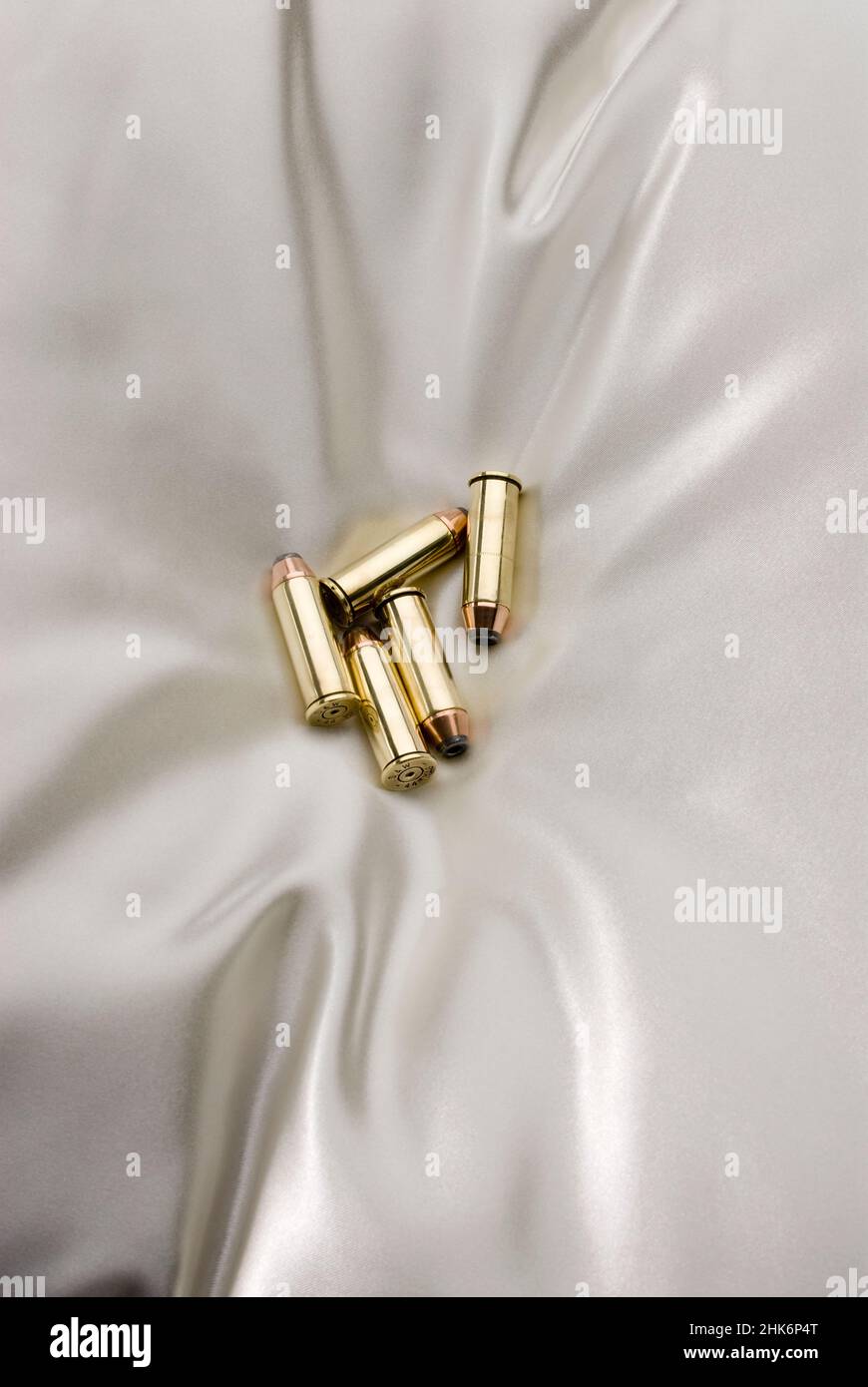 Group of bullets laying on satin pillow Stock Photo Alamy