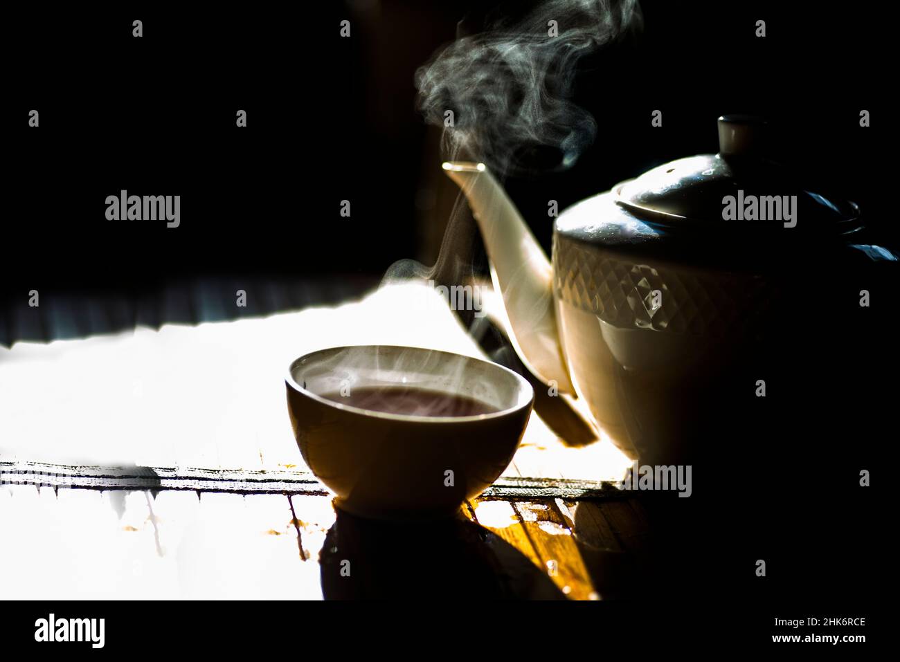 Steaming teacup, and classic china tea kettle Stock Photo
