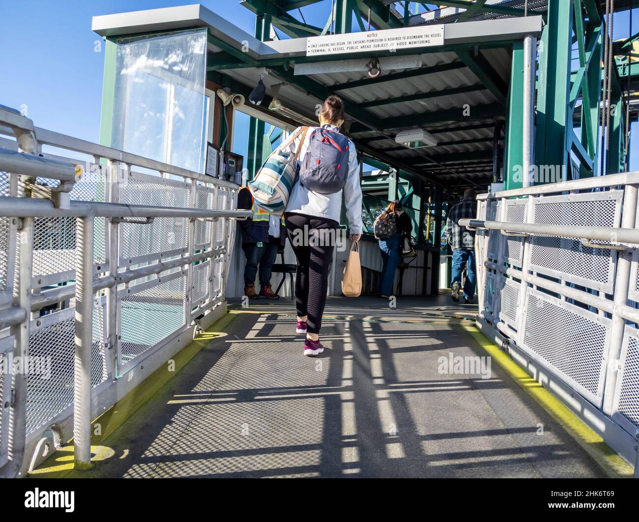 Friday Harbor, WA USA - circa November 2021: View of travelers making their way up the loading dock bridge onto the Washington State Ferry at San Juan Stock Photo