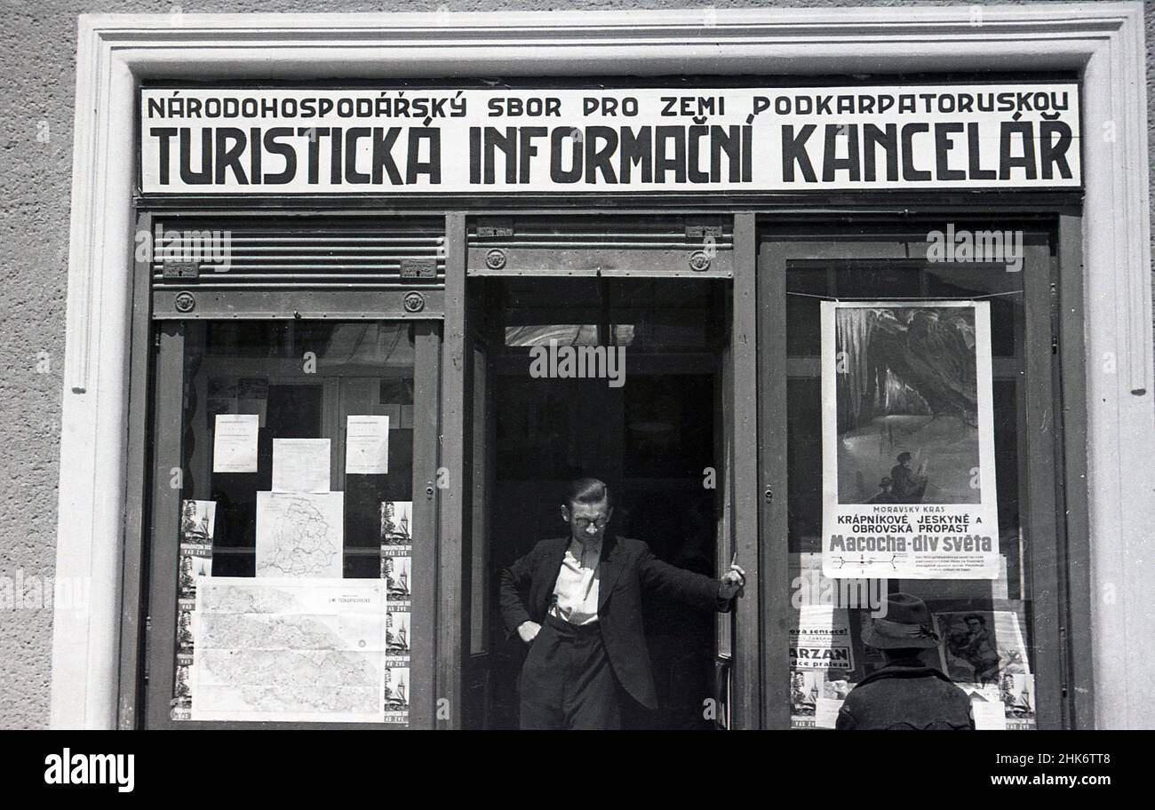 1930s, historical, pre-war Czechoslovakia, a man standing in the doorway of an early visitor information office, Turisticka Informacni Kancelar in this picture taken by J Allan Cash, who toured Eastern Europe in this era. A poster for Macocha -div Sevta is displayed in the window. Stock Photo