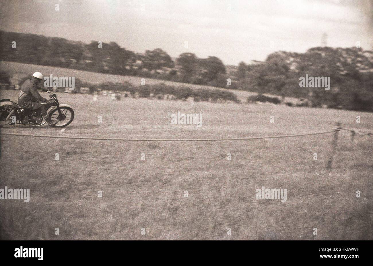 1950s, historical, scrambling, a male rider on his motorcycle racing across a hillside field, England, UK. Started in Camberley, Surrey, England in the 1920s, the bikes used orginally in the cross-country racing were ordinary roadbikes with little suspension. Stock Photo