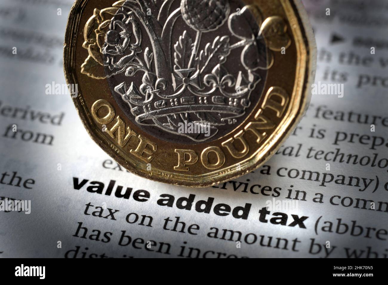 DICTIONARY DEFINITION OF WORD VALUE ADDED TAX WITH ONE POUND COIN RE VALUE ADDED TAX INFLATION COST OF LIVING VAT ETC UK Stock Photo