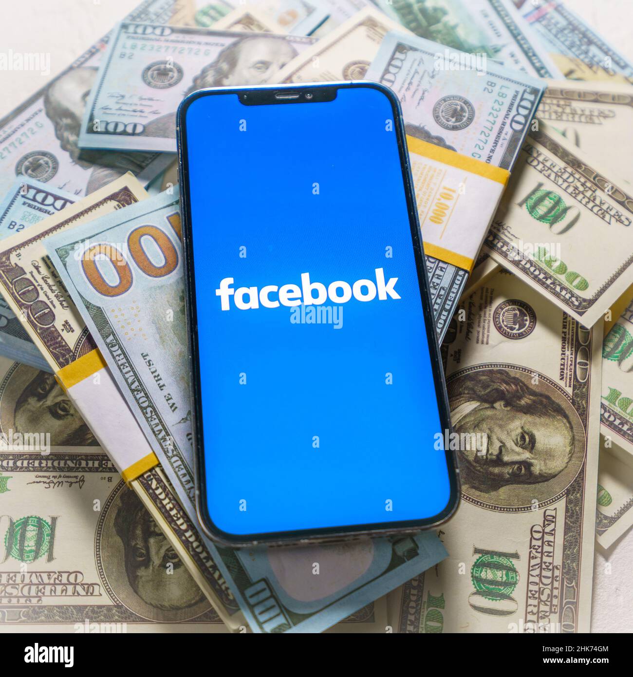 Berlin, Germany - February 02, 2022: iPhone 12 Pro Max with FACEBOOK META company logo placed on US dollar bills Stock Photo