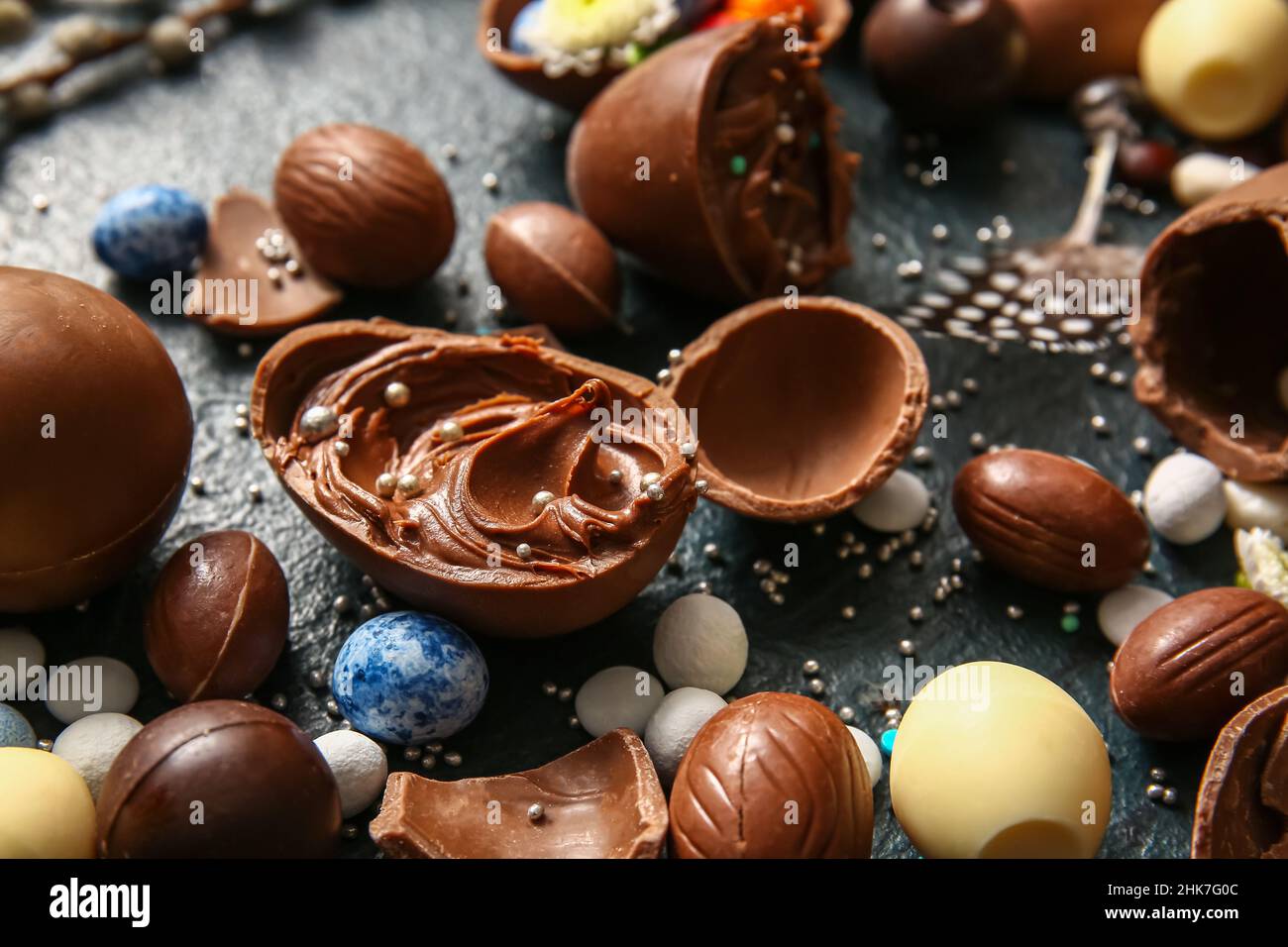 Easter eggs with chocolate paste and candies on dark background, closeup Stock Photo