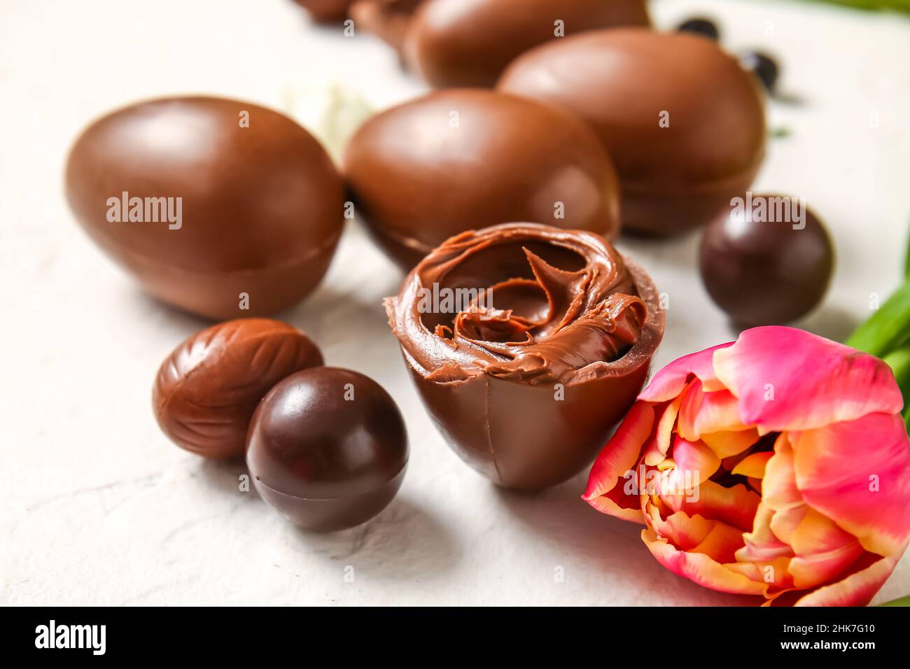Easter egg with chocolate paste and flower on light background, closeup Stock Photo