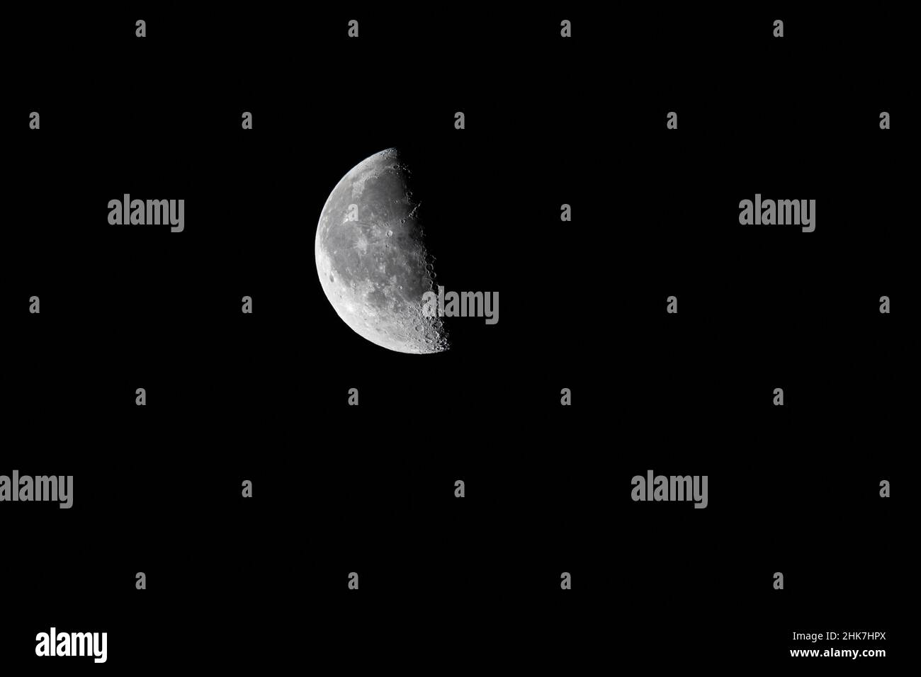 Closeup of the waning moon  - half moon - early morning against black sky. Stuttgart, Germany January 25, 2022 Stock Photo