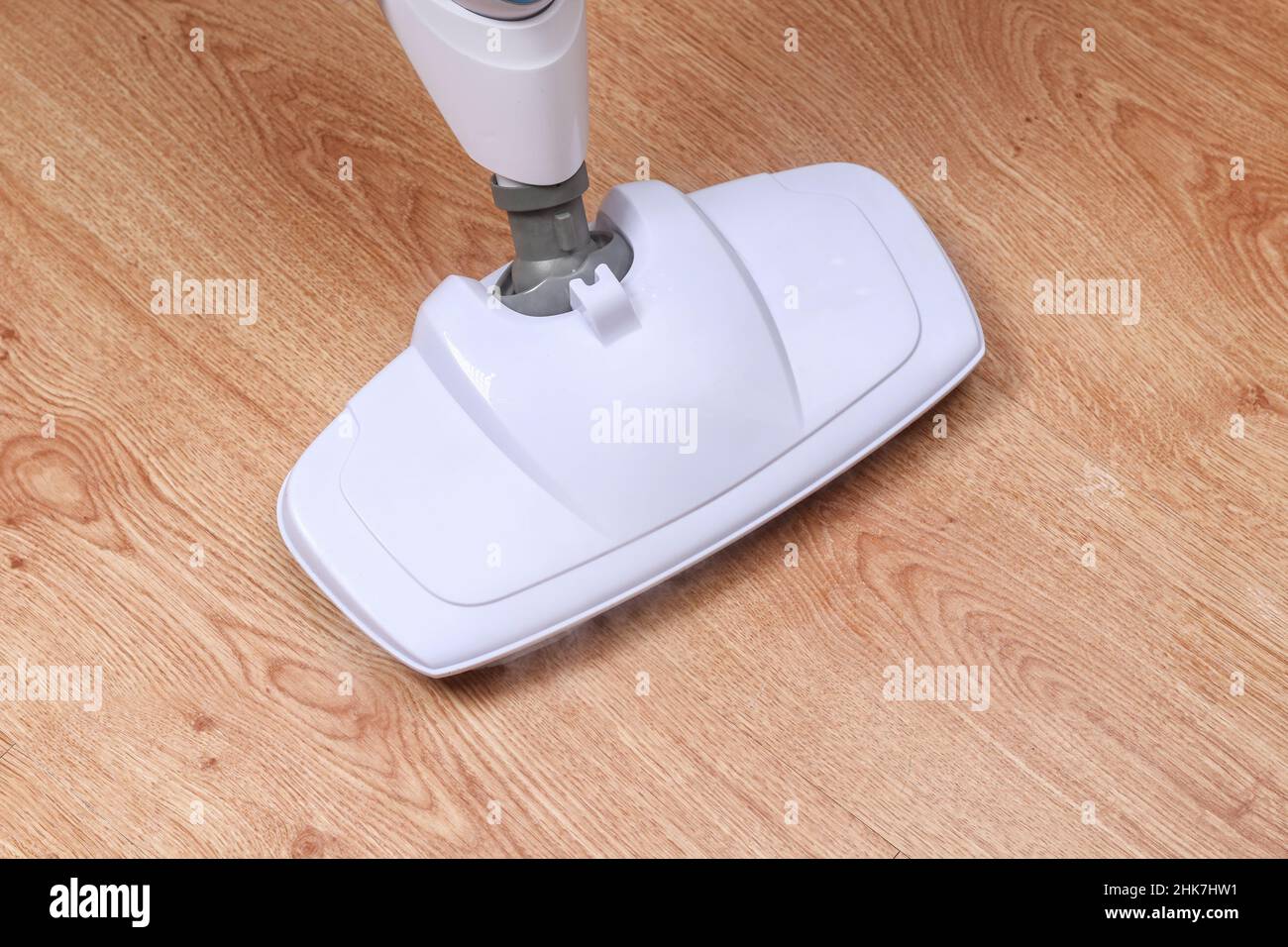 A man washes laminate flooring with a steam mop. Killing germs, clean floor, decontamination