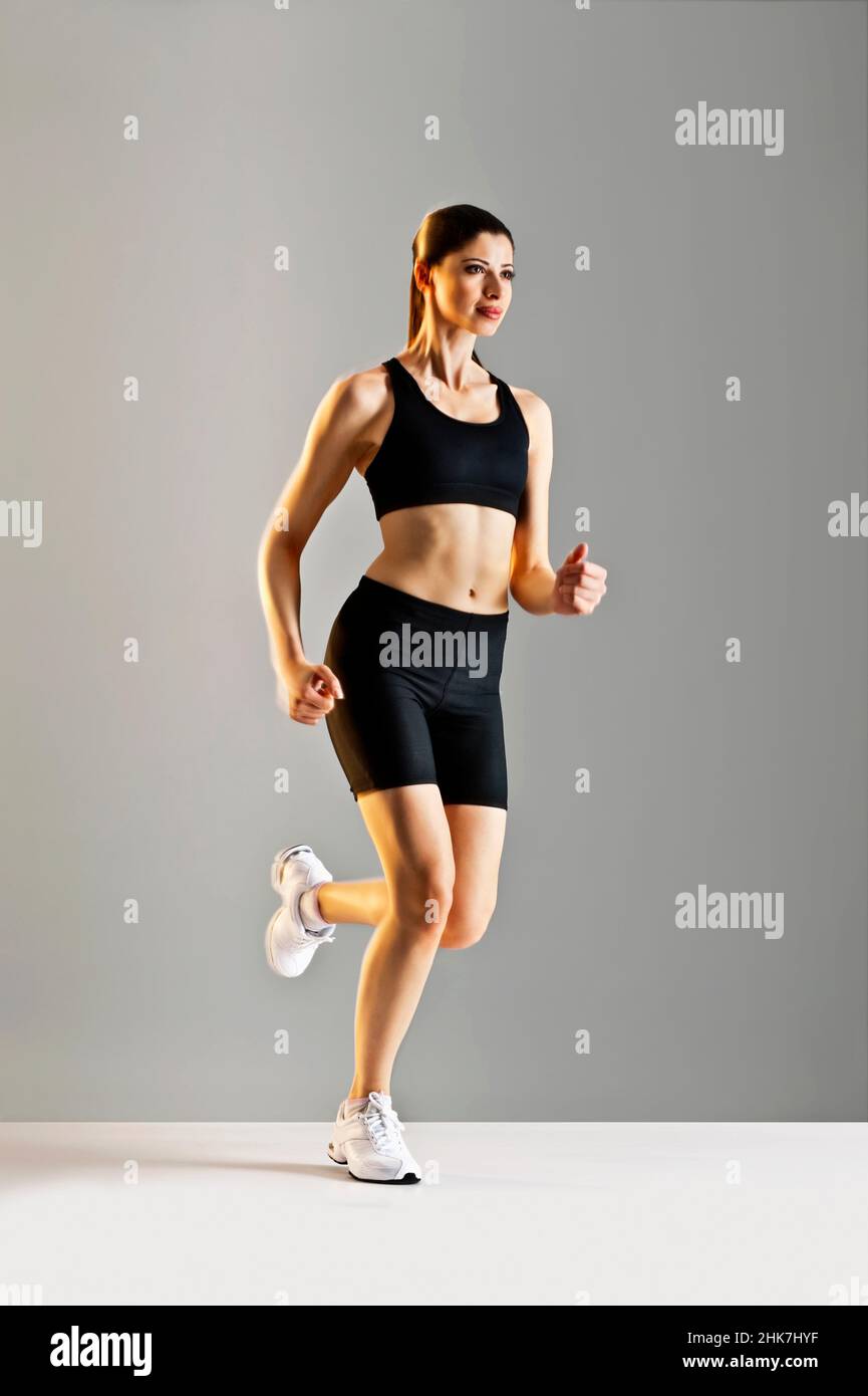 Young Caucasian woman running wearing black sports clothing Stock Photo