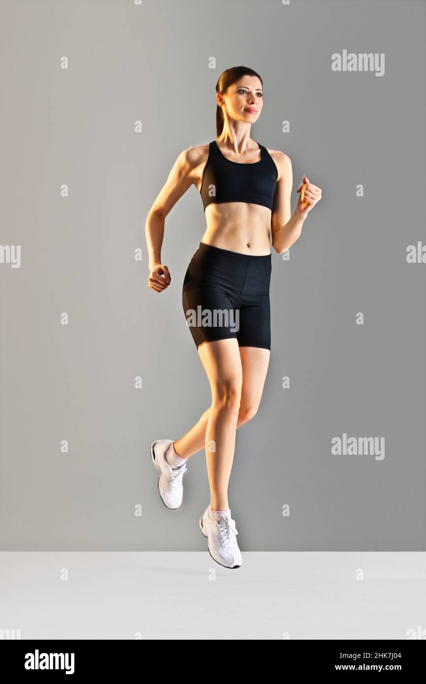 Young Caucasian woman running wearing black sports clothing Stock Photo
