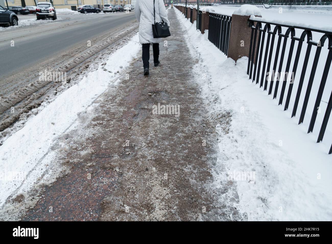 Selective focus on technical salt grains on icy sidewalk surface in ...