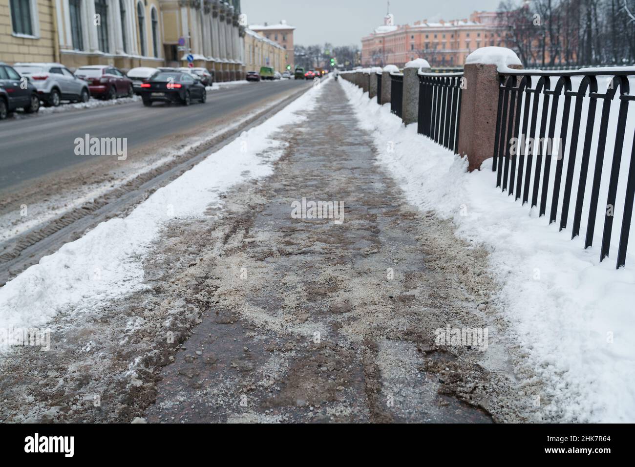 Closeup view of technical salt grains on icy sidewalk surface in