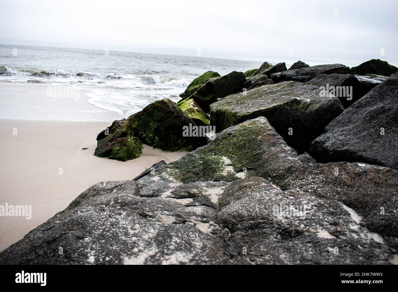 Shoreline on a cloudy day With Big Rocks with Moss Cape May New Jersey Stock Photo