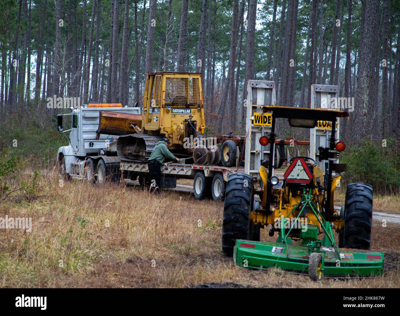 Glenn Catoe, a conservation law enforcement officer and game warden, unloads a small D4 dozer and a heavy forestry disk at Marine Corps Air Station (MCAS) Cherry Point, North Carolina, Jan. 25, 2022. The conversion is intended to promote wildlife habitat enhancement and provide recreation for MCAS Cherry Point personnel and their families. (U.S. Marine Corps photo by Lance Cpl. Symira Bostic) Stock Photo