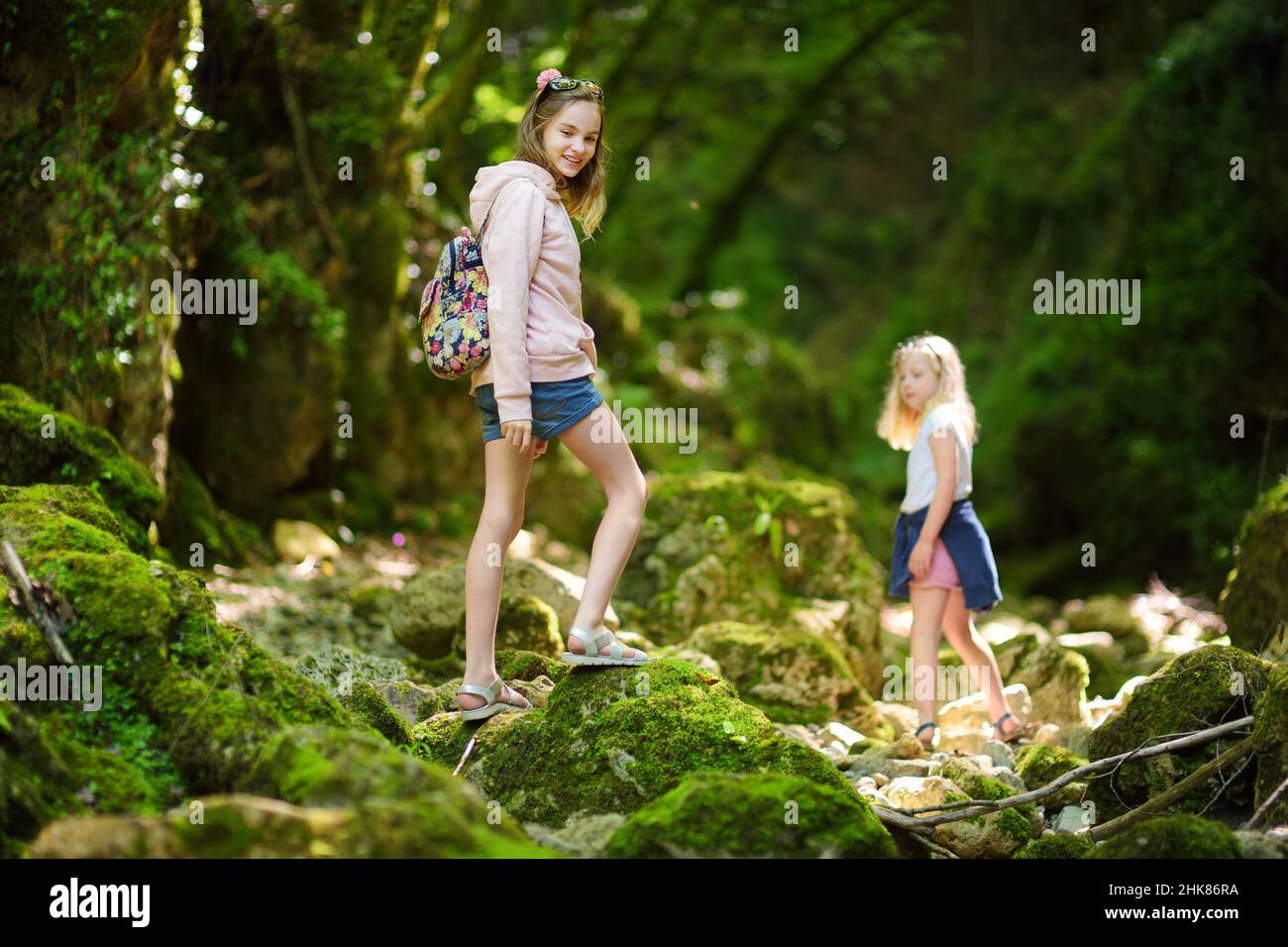 Young girls hiking in Botro ai Buchi del Diavolo, rocky gorge hiking trail, leading along dried up river. Beautiful footpath extending into the woods Stock Photo