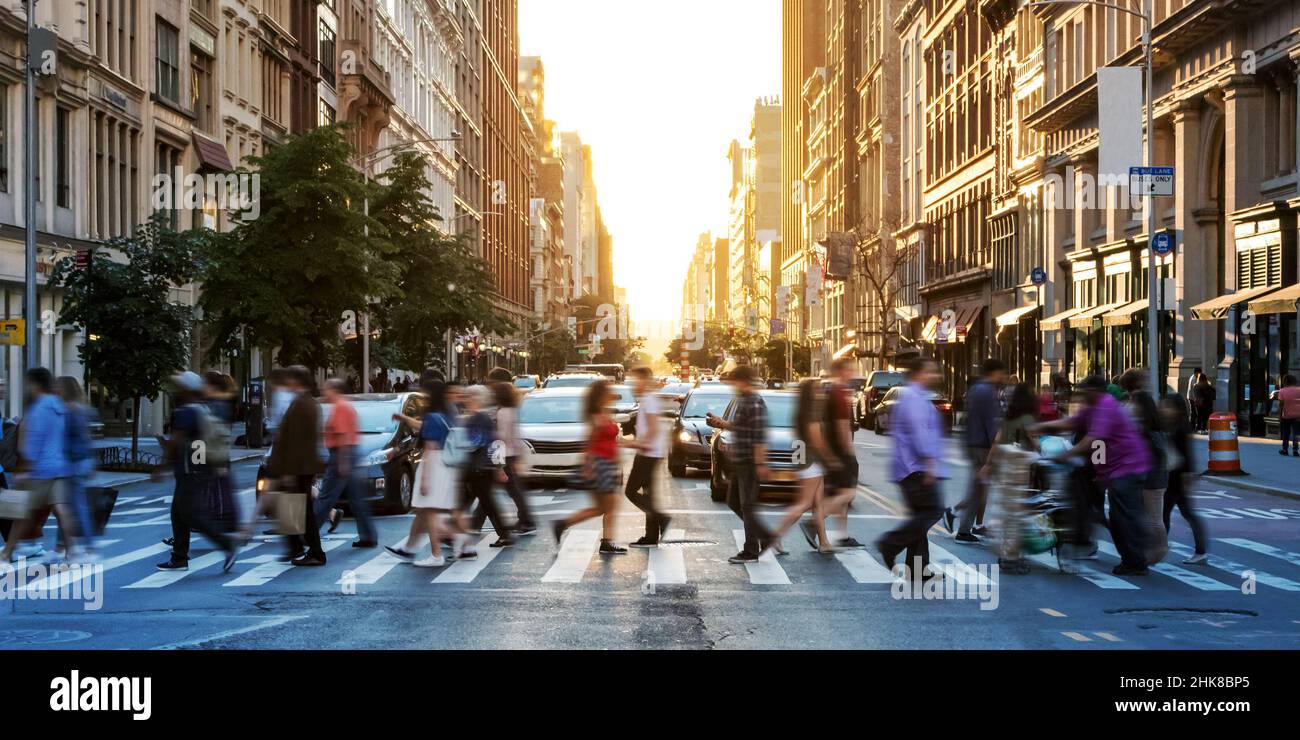 Crowds of people walking across a busy crosswalk at the