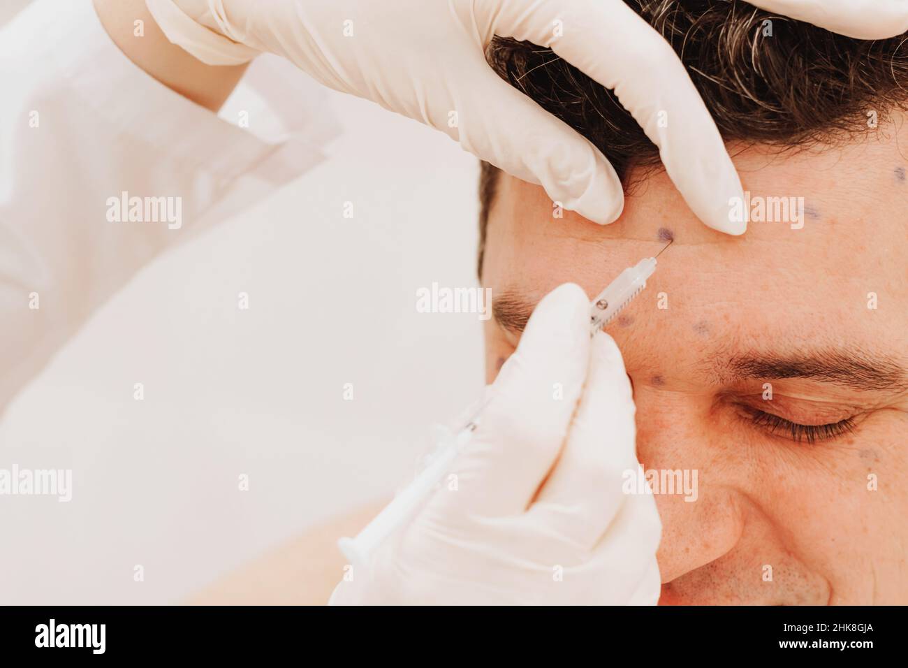 Cosmetologist conducts rejuvenation procedure puts Botox injection on man. The concept rejuvenating treatments Stock Photo