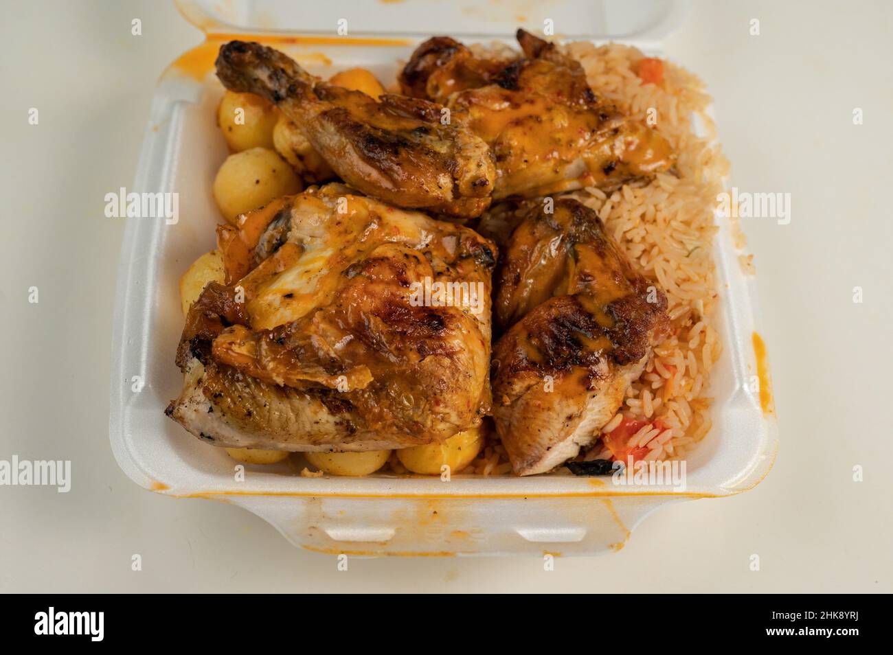 Portuguese Peri Peri Chicken on top of rice and potato balls in a Styrofoam dish Stock Photo Alamy