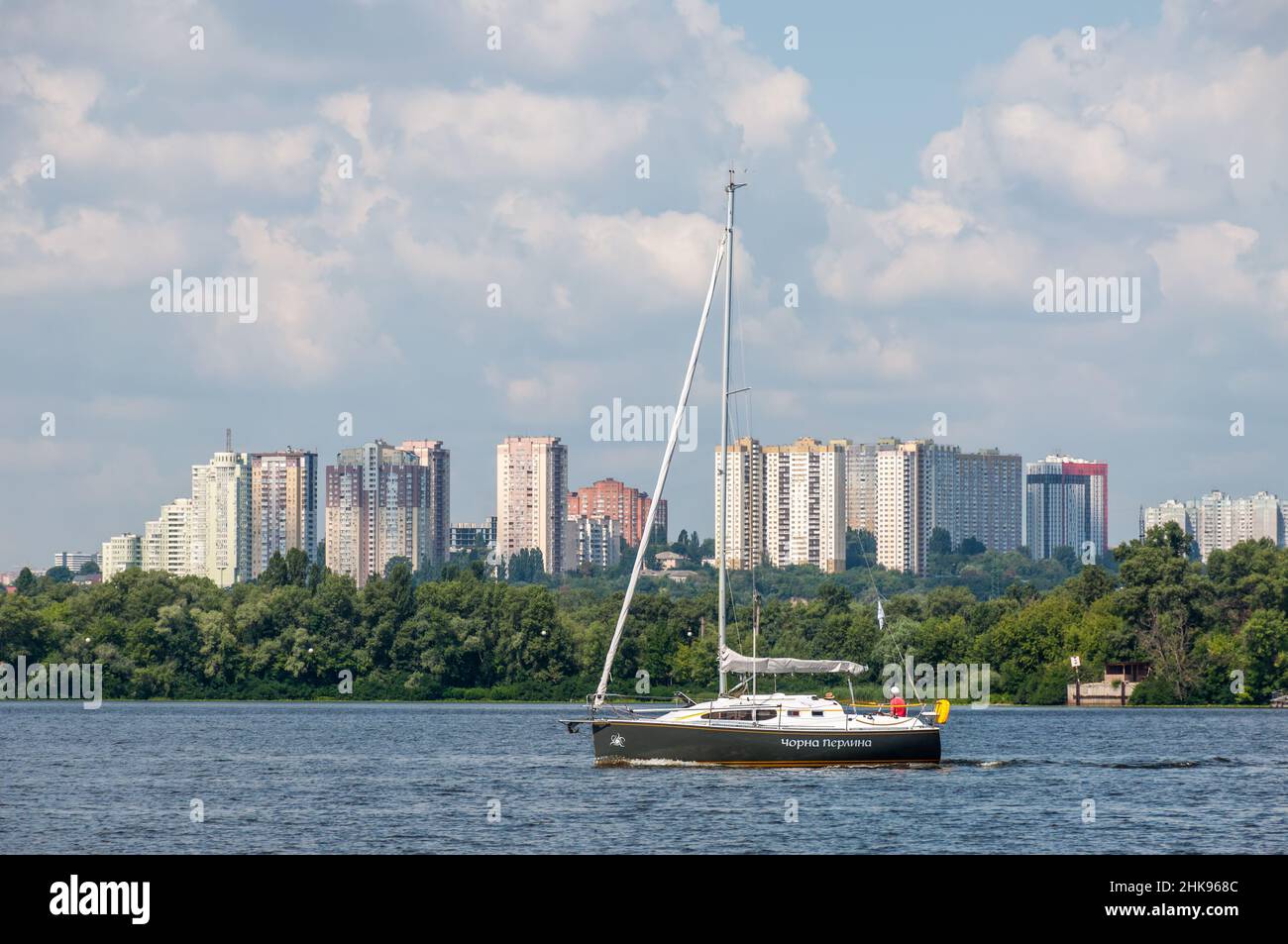 Kyiv, Ukraine - July 3, 2021: Yacht Black Pearl sail along the Dnipro river against the backdrop of a residential area in Kyiv, Ukraine. Stock Photo