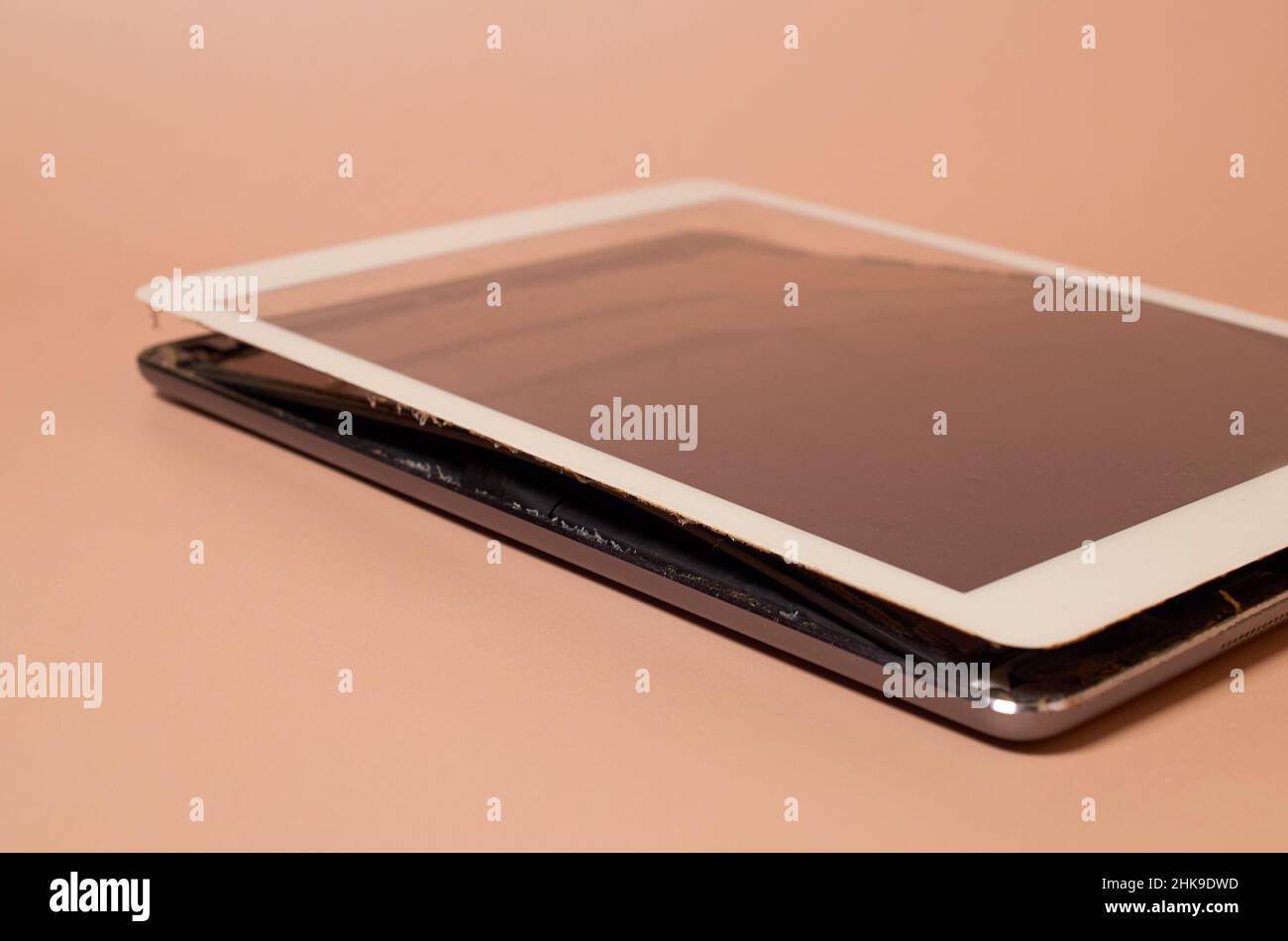 A broken tablet with a swollen battery and a dirty screen Stock Photo