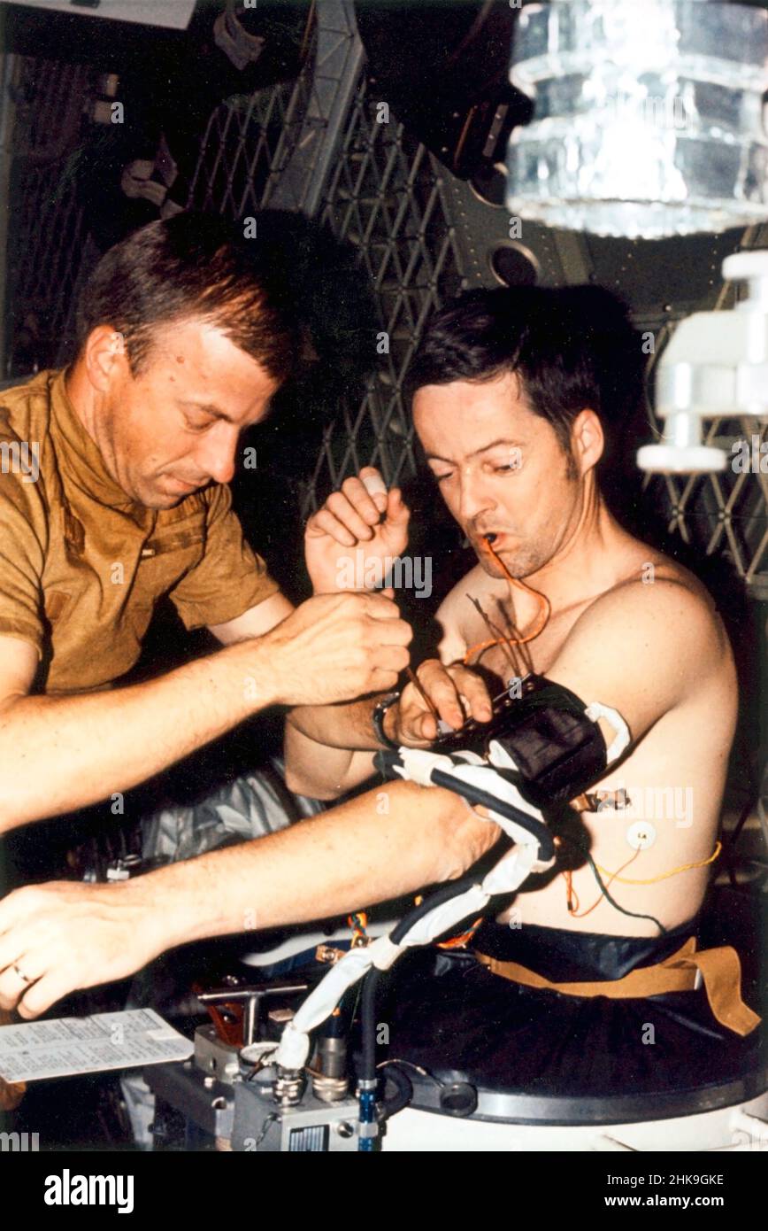 Astronaut Weitz assists Astronaut Kerwin with blood pressure cuff. Skylab-2 mission duration 5/25/73 thru 6/22/73. Stock Photo