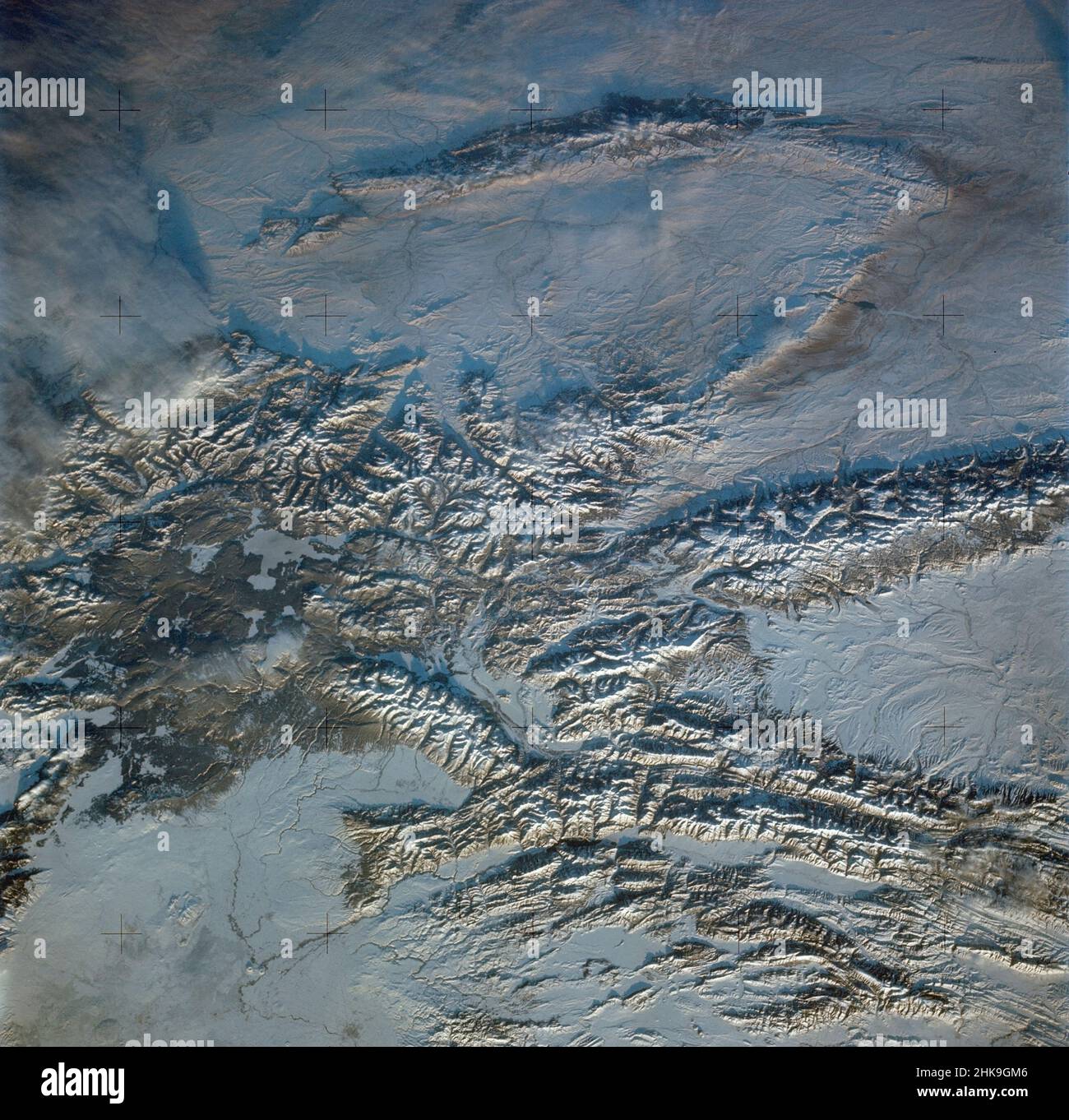 (February 1974) --- A near vertical view of the snow-covered northwest corner of Wyoming as seen from the Skylab space station in Earth orbit. A Skylab 4 crewman used a hand-held 70mm Hasselblad camera to take this picture. A small portion of Montana and Idaho is seen in this photograph also. The dark area is Yellowstone National Park. The largest body of water is Yellowstone Lake. The Absaroka Range is immediately east and northeast of Yellowstone Lake. The elongated range in the eastern part of the picture is the Big Horn Mountain range. The Wind River Range is at bottom center. The Grand Te Stock Photo