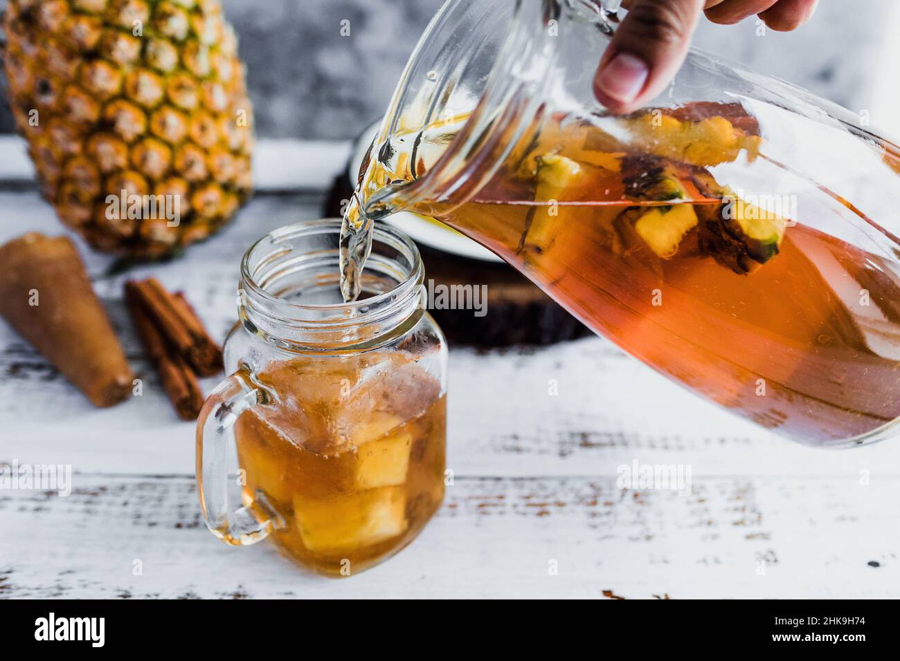 Tepache mexican Fermented pineapple drink and hand holding a Jar with kombucha homemade