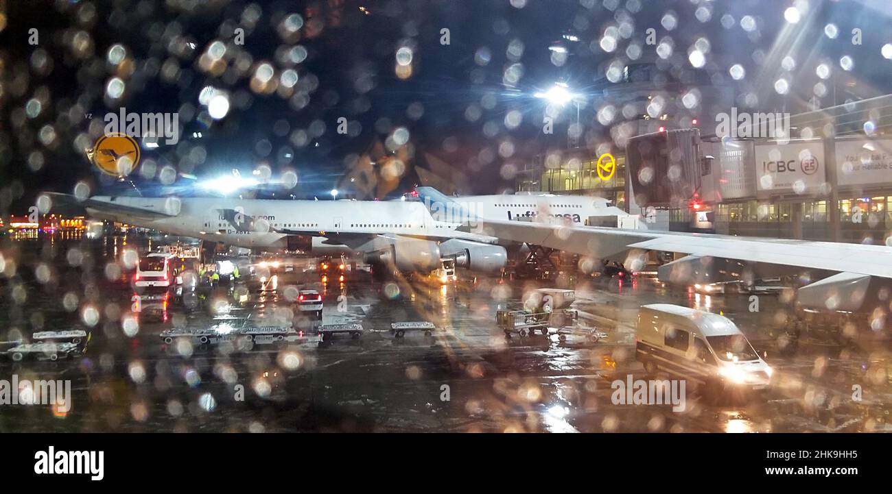 Frankfurt-am-Maim airport at night during the winter months in snow and rain with Lufthansa Boeing 747-400 jet waiting to leave. Stock Photo