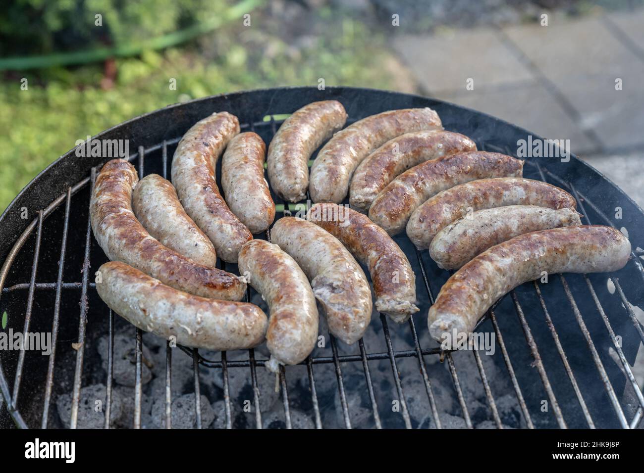Barbecue grill bbq on coal charcoal grill with raw bratwurst sausages meat delicious summer meal. Stock Photo