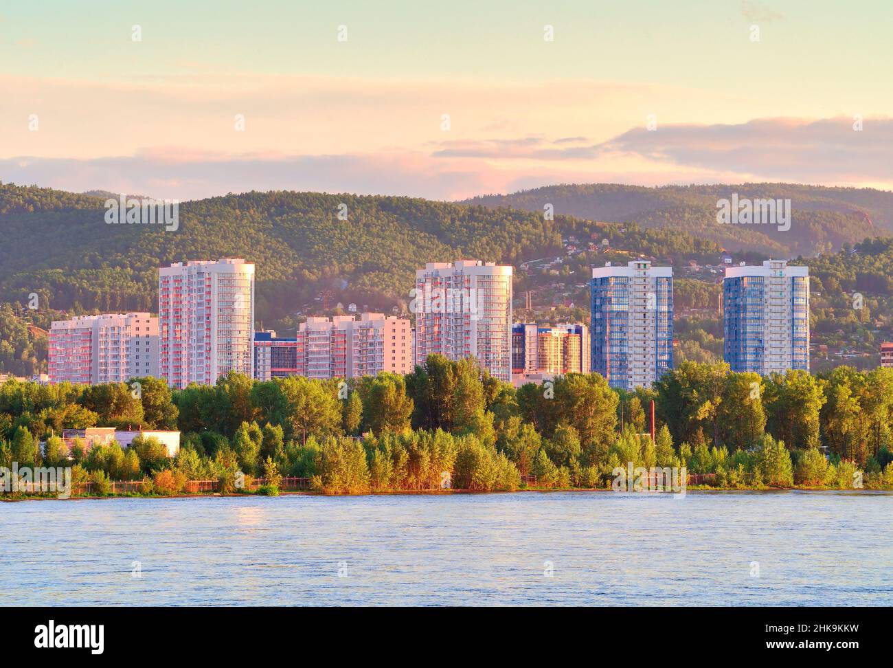 Construction of Yaryginskaya embankment on the bank of the Yenisei River against the background of green hills. Siberia, Russia Stock Photo