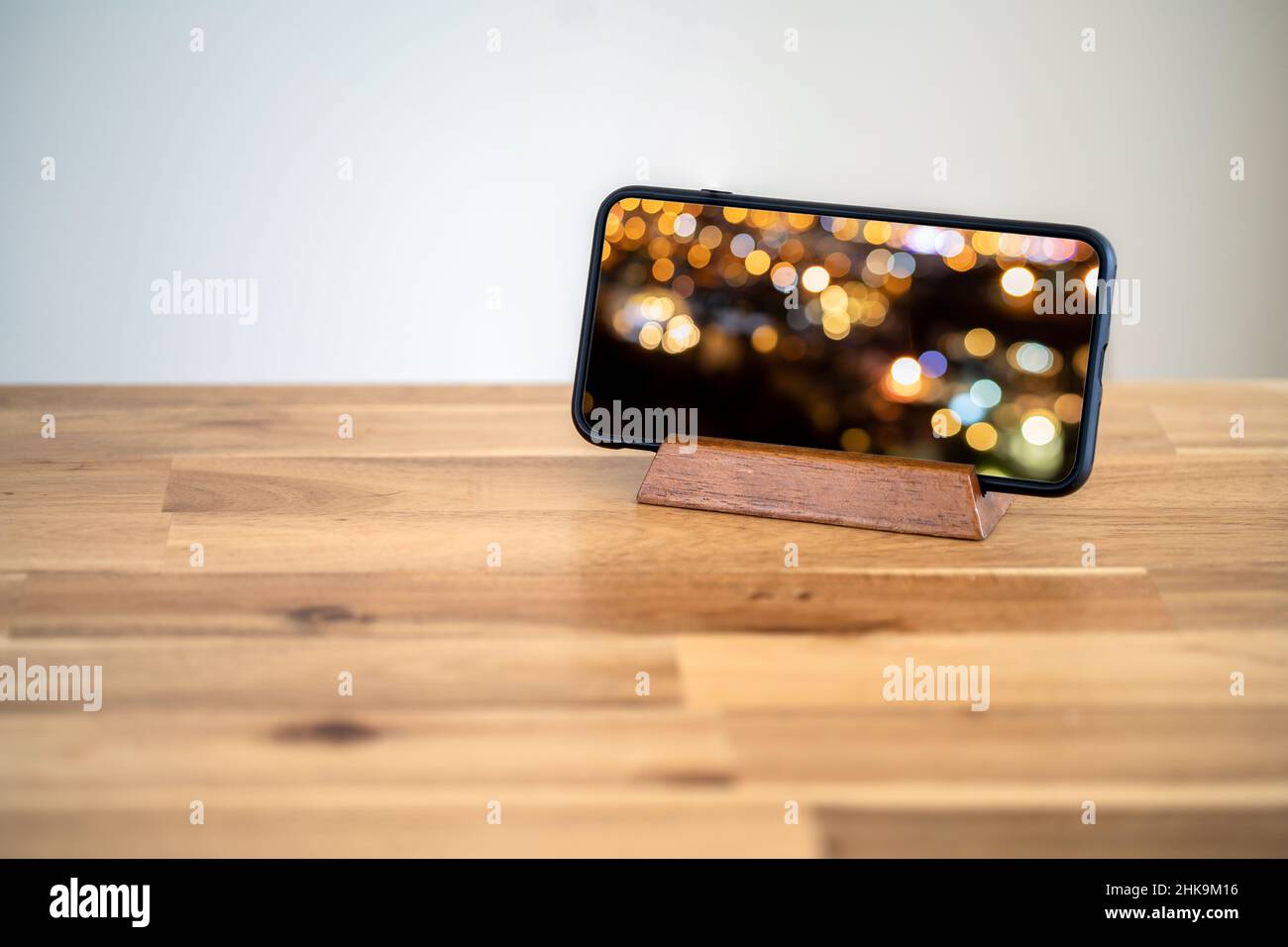 Smartphone standing on the table with scrren mocked up. video watching concept. Stock Photo