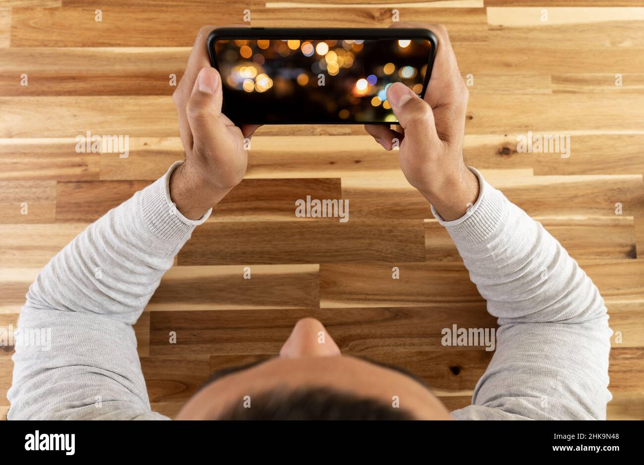 Top view photo of man watching video  or playing mobile game. Screen mockup. Stock Photo