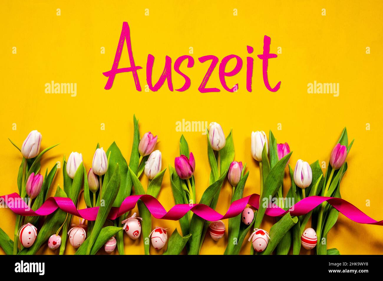 German Text Auszeit Means Downtime. White And Pink Tulip Spring Flowers With Ribbon And Easter Egg Decoration. Yellow Wooden Background Stock Photo