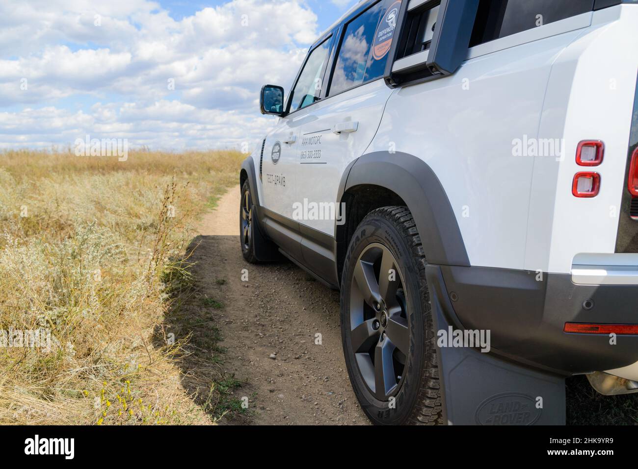 Russia, Rostovskaya oblast, 2021 June 09: Modern new SUV car Land Rover Defender, test drive on dirty road. Offroad 4x4 driving in wild. Stock Photo